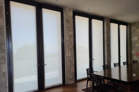 Contemporary Calabasas living room with electric custom roller shades fully deployed to darken the room for movie watching.