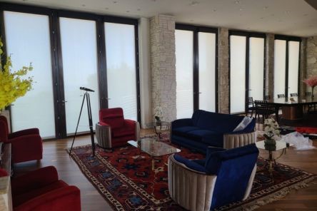 Contemporary Calabasas living room with electric custom roller shades fully deployed to darken the room for movie watching.